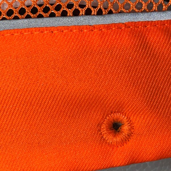 Detalle de gorra de seguridad GERF SAFETY naranja fluorescente con ventilación y banda reflectante.