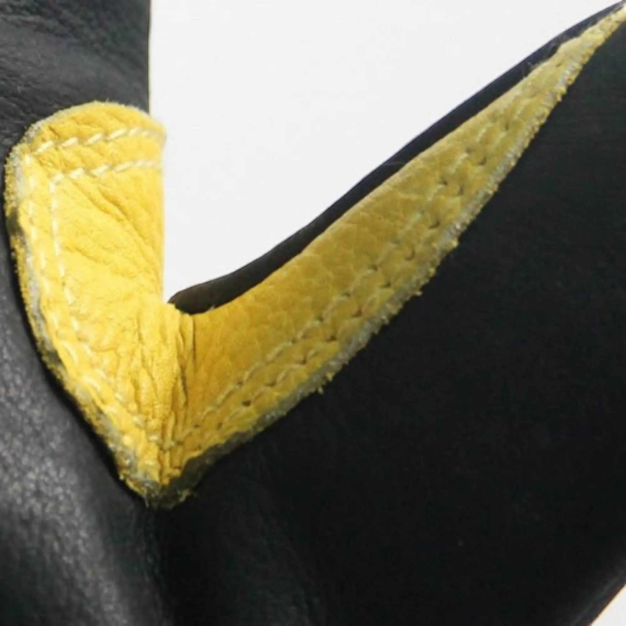 Detalle de costuras reforzadas en guantes de bombero GERF SAFETY de cuero negro con inserciones amarillas