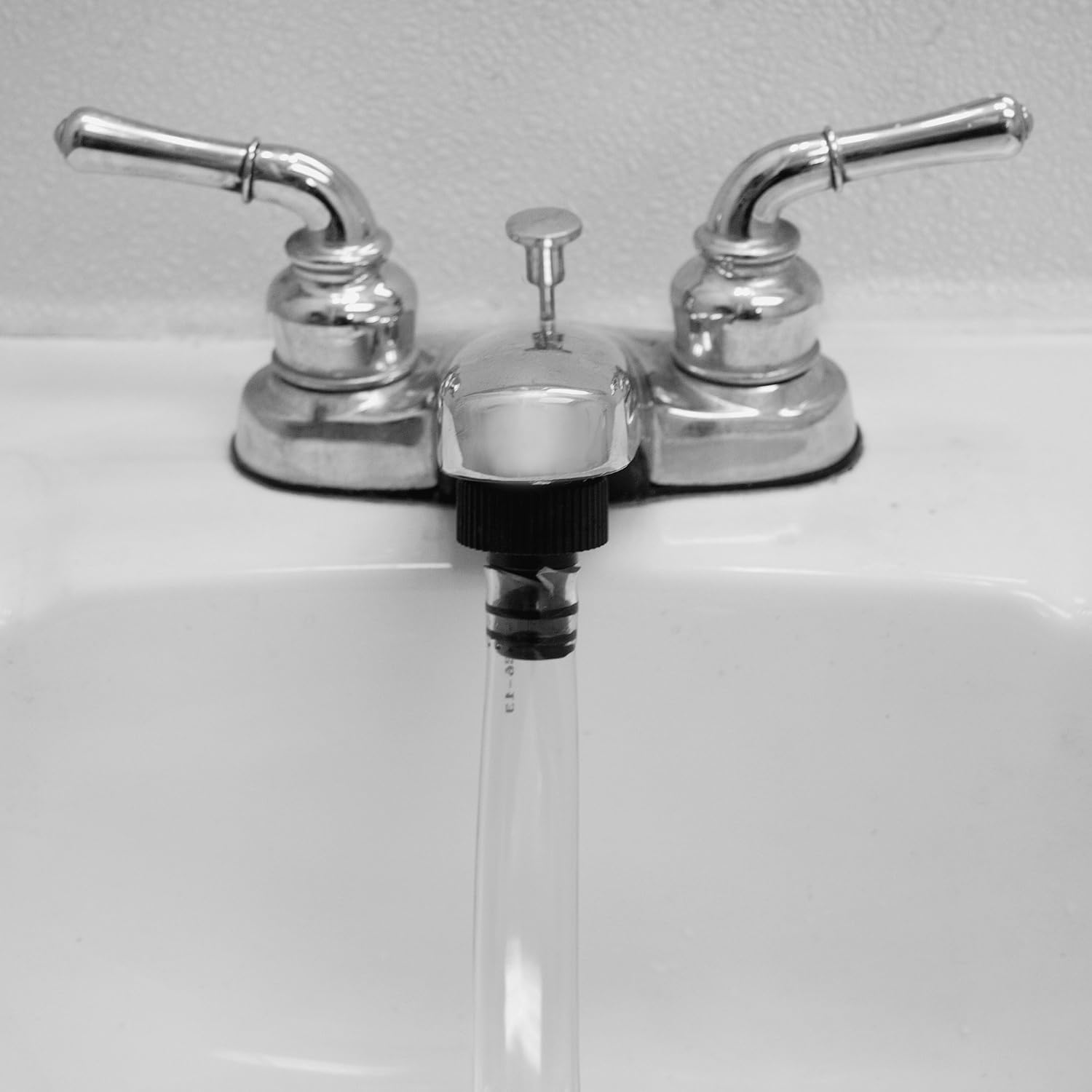 Manguera de llenado GERF SAFETY conectada a un grifo cromado para el sistema de almacenamiento de agua de emergencia